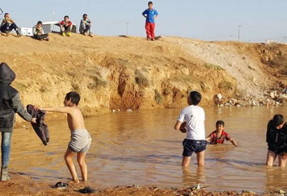 بالصور.. أطفال الزعتري يسبحون بمستنقعات اختلطت