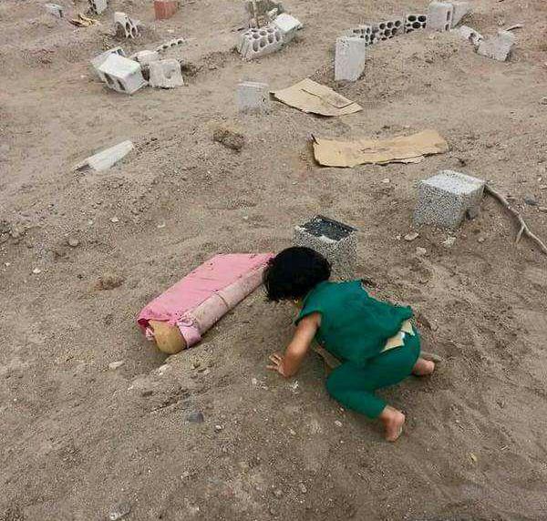 طفلة عدنية تقبل قبر أبيها