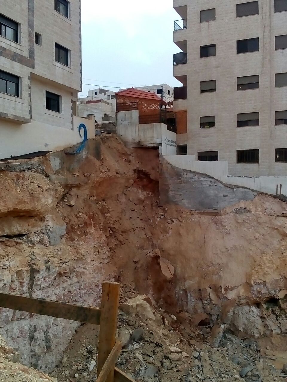 بالصور .. حفرة إنشائية تهدد بانهيار