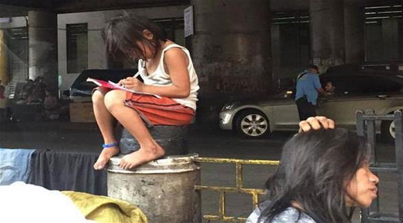 طفلة فقيرة تكتب وظيفتها المدرسية في