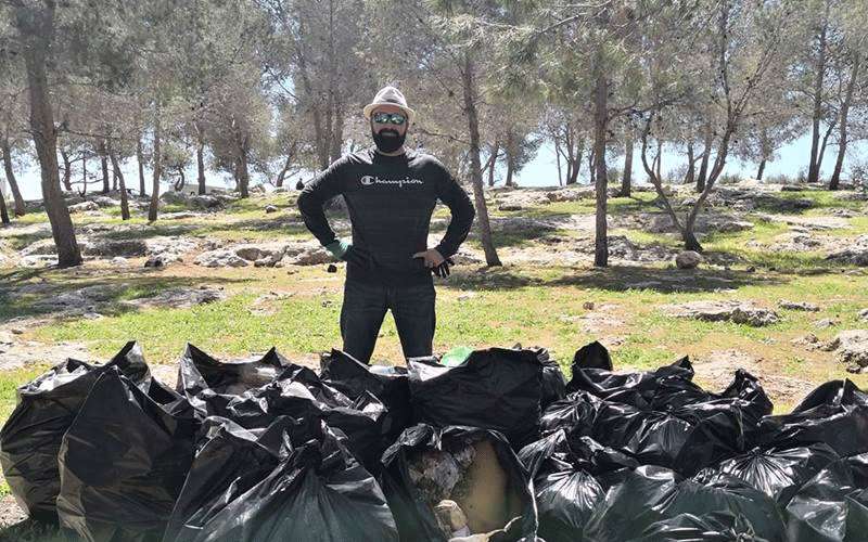 شاب يجمع اكواما من مخلفات المتنزهين