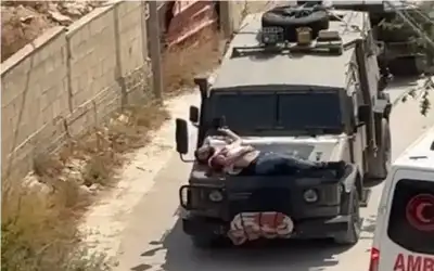 القوات الإسرائيلية تقيد فلسطينيا جريحا فوق