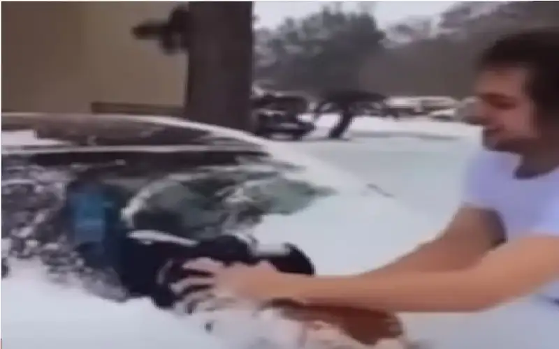 شاهد.. أب يمسح الثلج عن سيارته