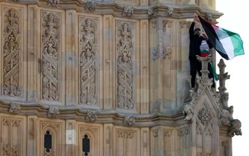 رجل يتسلق برج بيغ بن رافعا