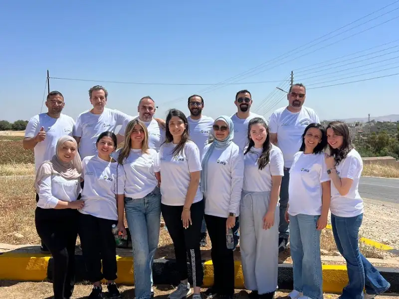 البنك الاردني الكويتي ينفذ حملة لموظفيه لطلاء أرصفة مساره المتبنى على طريق السلط-ارميمين