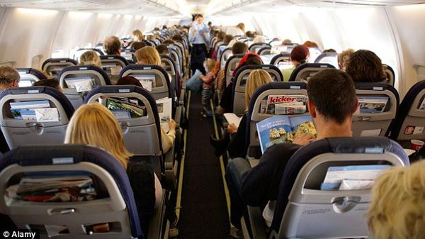 مسافر يفتح باب طائرة لاستنشاق الهواء