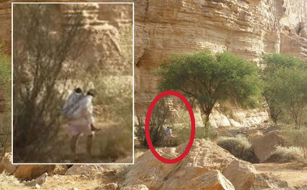 مواطن يحمل والدته المسنة على ظهره