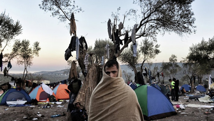 مزارع يوناني يحاول حرث مخيم للاجئين