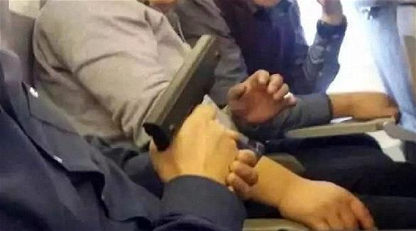 مسافرون يلتقطون صورا مع مسدس على